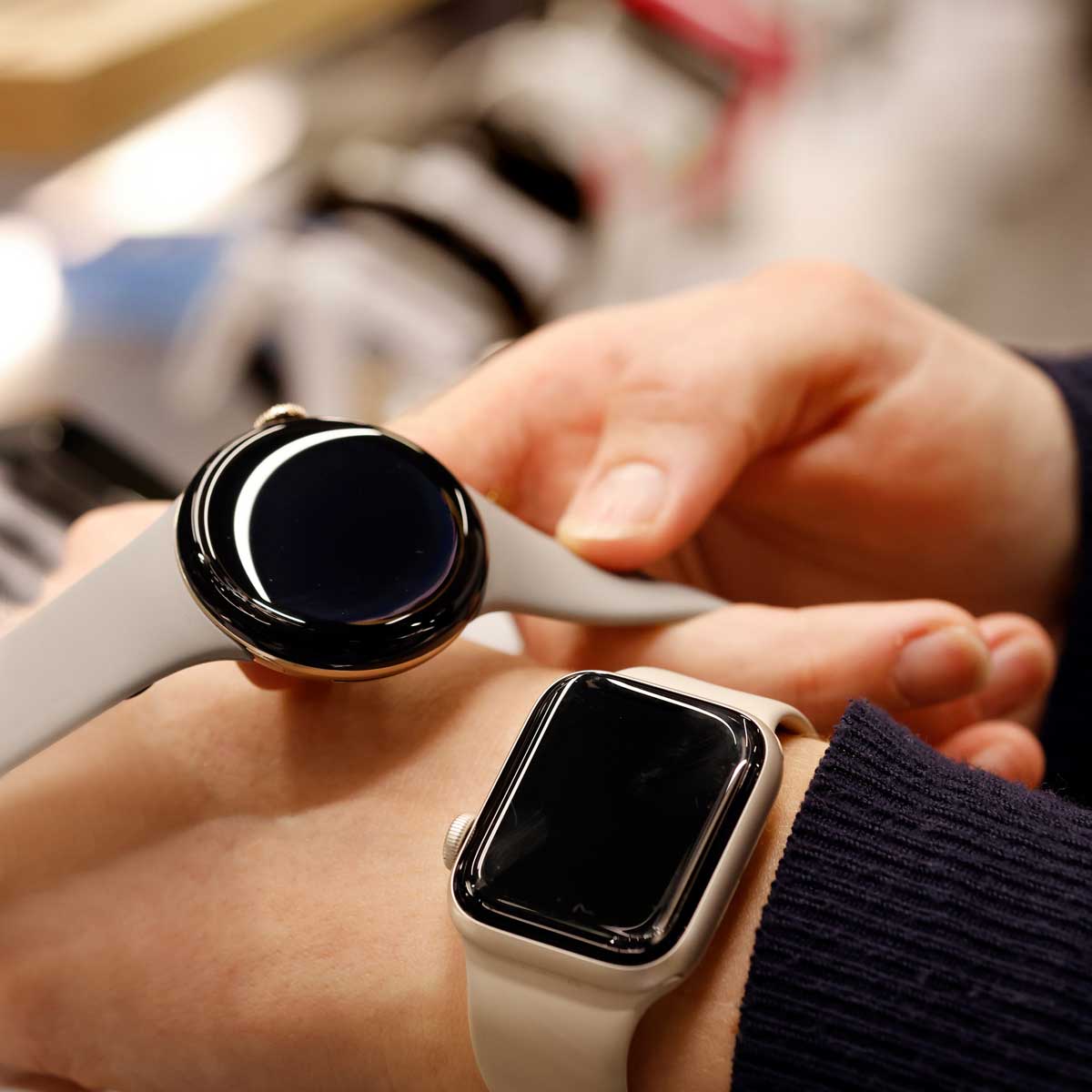 Billede af kunde, der prøver to smartwatch i Lyngby Storcenter